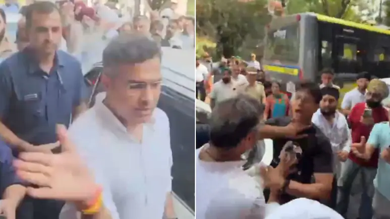 Delhi Minister Parvesh Verma, with his left hand, pulls down a young man's mobile while he was