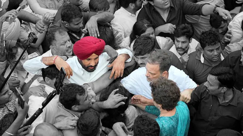 Raja Warring, removed last week as Punjab Congress chief, has his arms raised around Rahul